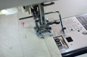 เย็บริมขอบซ้ายขวาให้แผ่นใยกับผ้าชิ้นนอกติดกัน